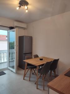a dining room with a table and a refrigerator at Povljana Maris in Povljana
