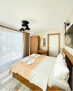 ein Schlafzimmer mit einem großen Bett und einem großen Fenster in der Unterkunft Ata Boutique Hotel in Altınyunus