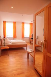 ein Schlafzimmer mit einem Bett und einem großen Spiegel in der Unterkunft Gasthof Hotel Bauer in Hersbruck