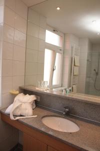 a bathroom with a sink and a mirror at Gasthof Hotel Bauer in Hersbruck