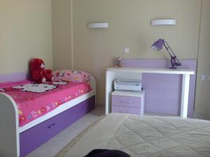 a childs bedroom with a pink and purple bed and a desk at 1этаж виллы на берегу Адриатики in Utjeha