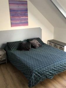 um quarto com uma cama com um edredão azul em Maison en pierre à la campagne proche de la mer em Plourhan
