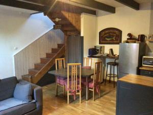 uma cozinha e sala de jantar com uma mesa e uma escada em Maison en pierre à la campagne proche de la mer em Plourhan
