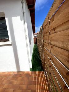 een houten hek aan de zijkant van een gebouw bij Joli T2 à 1km de la chambre d'amour in Anglet