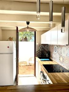 een keuken met een witte koelkast en een tafel bij Joli T2 à 1km de la chambre d'amour in Anglet