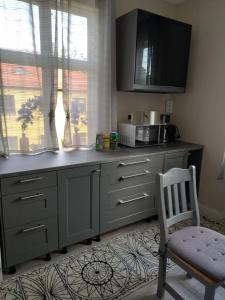 eine Küche mit einer Theke mit einer Mikrowelle und einem Stuhl in der Unterkunft 1 bedroom apartment, whole flat in Arvika