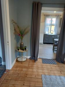 a room with a table and a vase with flowers on it at 1 bedroom apartment, whole flat in Arvika