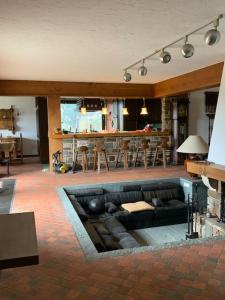ein Wohnzimmer mit einem Sofa und einer Küche in der Unterkunft Gîte des Hurlevents in Bourglinster
