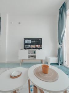 a living room with two white tables and a tv at Appartamenti San Lorenzo 1 in Reitani