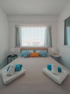 1 dormitorio con 1 cama grande con almohadas azules y naranjas en Appartamenti San Lorenzo 1, en Reitani