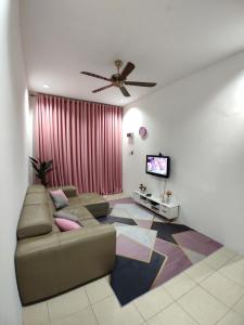 een woonkamer met een bank en een tv bij Wan K Homestay Gua Musang in Gua Musang