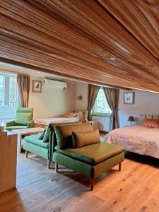 ein großes Schlafzimmer mit 2 Betten und einem grünen Sofa in der Unterkunft Gintarautojai in Palanga