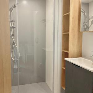 La salle de bains est pourvue d'une douche avec une porte en verre. dans l'établissement Domaine Les Acacias, à La Ville-aux-Dames