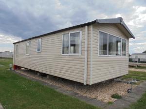 a tiny house is sitting in a yard at Kingfisher : Soleil:- 6 Berth, Central Heated, Close to site entrance in Ingoldmells