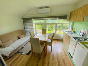 a kitchen and dining room with a table and a couch at Unaqua Apartments in Kulen Vakuf