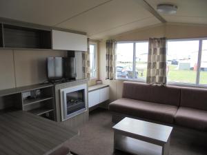 a living room with a couch and a tv at Kingfisher : Soleil:- 6 Berth, Central Heated, Close to site entrance in Ingoldmells