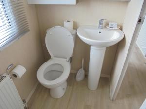 a bathroom with a toilet and a sink at Kingfisher : Soleil:- 6 Berth, Central Heated, Close to site entrance in Ingoldmells