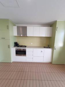 a kitchen with white cabinets and a tile floor at Colley 11-11 Sub-Penthouse Luxurious Glenelg in Glenelg