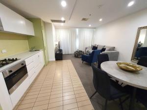 a kitchen and living room with a table and a couch at Colley 11-11 Sub-Penthouse Luxurious Glenelg in Glenelg