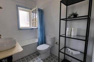 een badkamer met een toilet, een wastafel en een raam bij Casa Mimosa with private pool & garden in Agaete