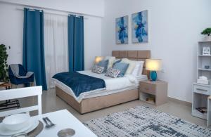 a bedroom with a bed with blue curtains at Cozy Sea View Studio at Al Hamra by FREE Holiday Homes in Ras al Khaimah