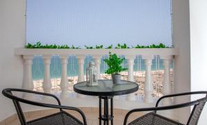 a table with two chairs and a window and a table with a plant at Cozy Sea View Studio at Al Hamra by FREE Holiday Homes in Ras al Khaimah
