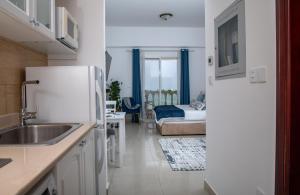 a kitchen with a refrigerator and a bedroom with a bed at Amazing sea view studio in Ras al Khaimah