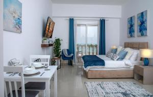 ラス・アル・ハイマにあるCozy Sea View Studio at Al Hamra by FREE Holiday Homesのベッドとダイニングルームのあるリビングルーム