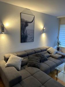 a couch in a living room with a picture of a bull at 1 - Zimmer Appartement - kleine Harzperle in Langelsheim