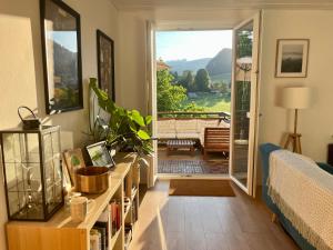 a living room with a door open to a patio at Mountain Vista Apartment in Bled