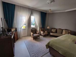 Villa Mercury (4 bedrooms and air conditioning) في طرابزون: غرفة نوم بسرير وكراسي وتلفزيون