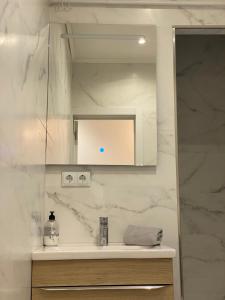 bagno bianco con lavandino e specchio di Cozy near the Barcelona Camp Nou Stadium a Barcellona