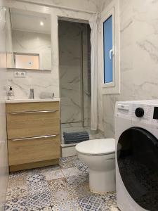 a bathroom with a toilet and a shower and a washing machine at Cozy near the Barcelona Camp Nou Stadium in Barcelona