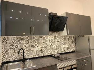 a kitchen with a sink and a tiled wall at Cozy near the Barcelona Camp Nou Stadium in Barcelona
