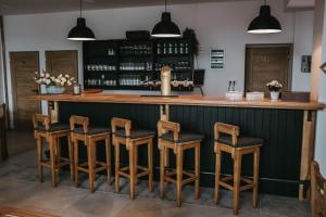 的住宿－Restaurace a penzion U svaté Barbory，吧台上设有四张木凳的酒吧