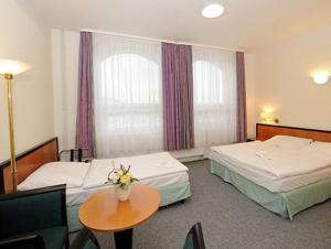 ein Hotelzimmer mit 2 Betten und einem Tisch in der Unterkunft Restaurace a penzion U svaté Barbory 