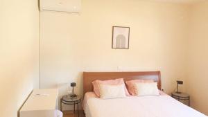 - une chambre avec un lit doté de draps blancs et d'oreillers roses dans l'établissement Apartment Helios 1, à Lokva Rogoznica