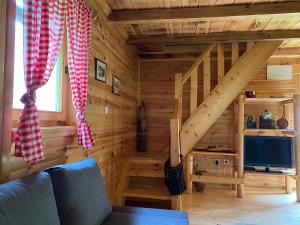 a log cabin with a staircase and a television at Holiday Home Milica in Kolašin