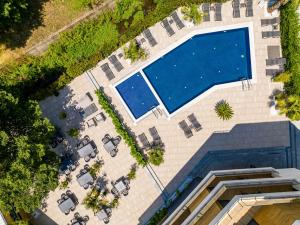 an overhead view of a swimming pool with lounge chairs at Touch Hotel in Lozenets