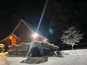 ein Haus mit einem Zaun im Schnee in der Nacht in der Unterkunft Holiday Home Milica in Kolašin