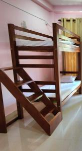 Ce lit superposé se trouve dans une chambre située à côté d'un mur. dans l'établissement Cross Ceylon, à Negombo