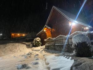 ein Haus mit Schnee in der Nacht und Lichtern in der Unterkunft Holiday Home Milica in Kolašin