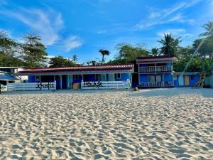 a house on the beach with a sandy beach at Khafii House in Kampong Pasir Panjang
