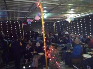 a group of people sitting in a room with christmas lights at Backpackers Park Varanasi in Varanasi