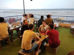 a group of people sitting at tables on a cruise ship at Backpackers Park Varanasi in Varanasi
