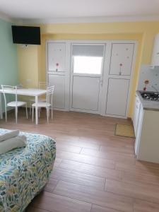 Habitación con cocina y mesa con cama. en Colori nel Parco 2, en Cesiomaggiore