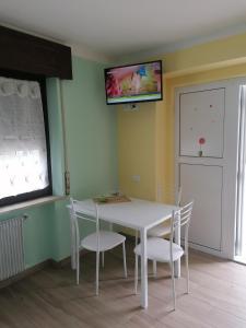 une salle à manger avec une table et des chaises blanches dans l'établissement Colori nel Parco 2, à Cesiomaggiore