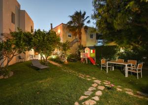a backyard with a table and chairs and a playground at Antonia in Plakias