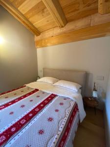 um quarto com uma cama com uma colcha vermelha e branca em Alpi Azzurre em Limone Piemonte