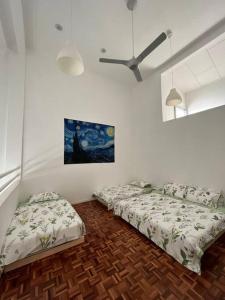 Cette chambre comprend deux lits et un ventilateur de plafond. dans l'établissement The Van Gogh Loft 梵高小栈 at Selesa Hillhomes, à Bukittinggi